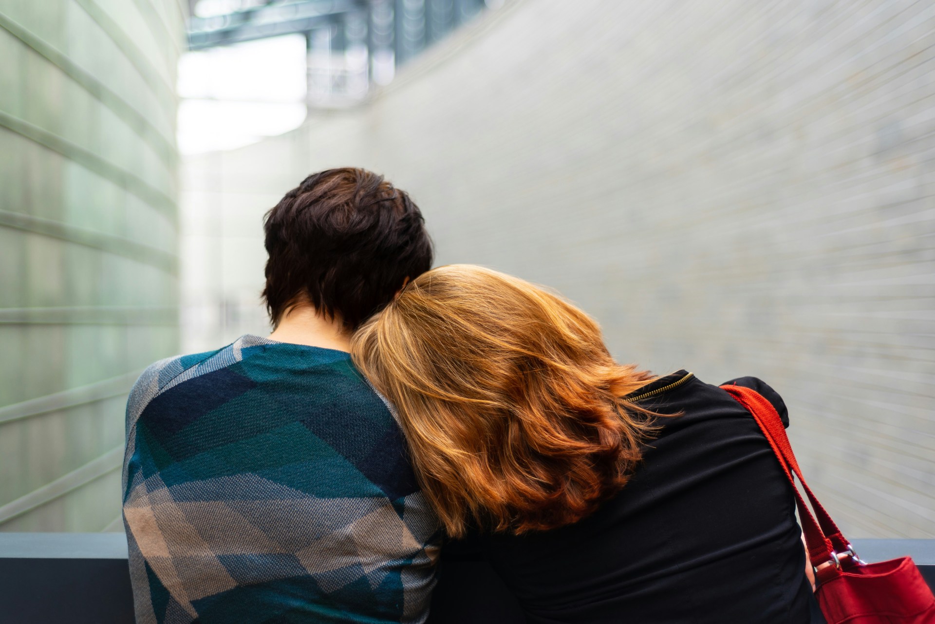 a person putting their head on another person's shoulders