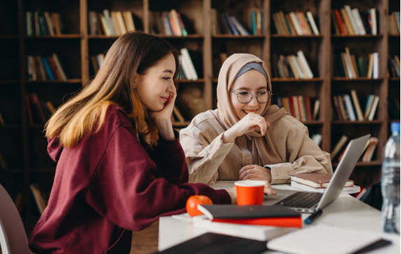 women smiling at laptop