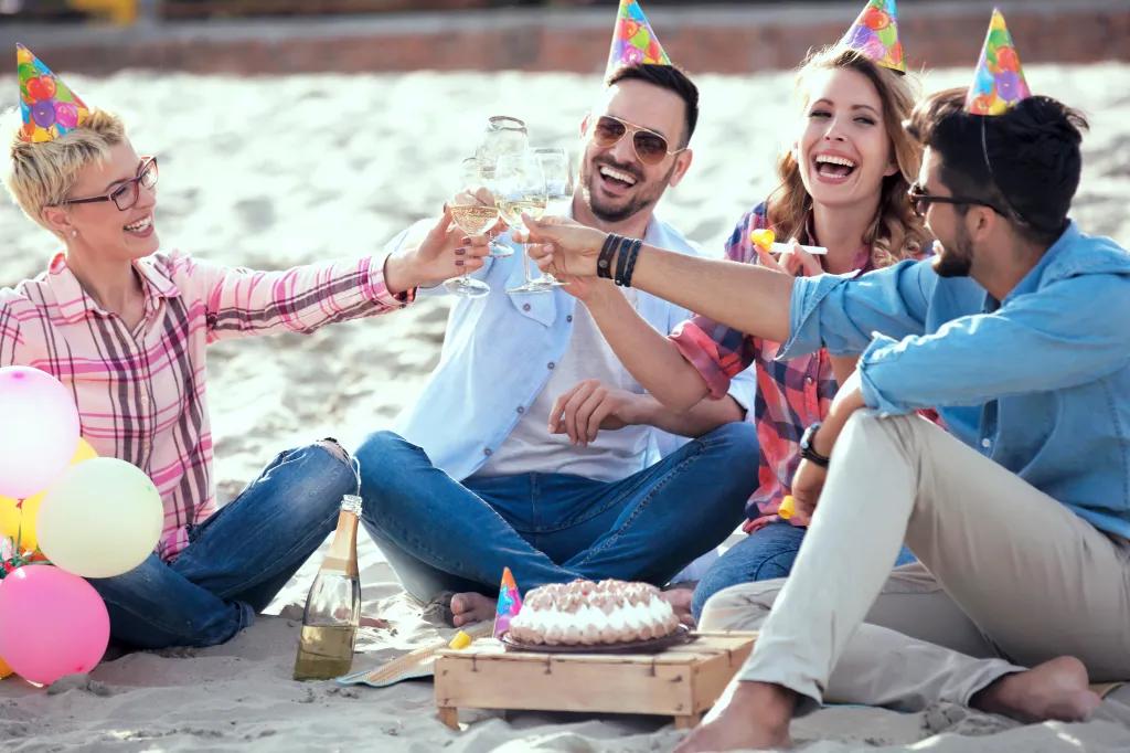 Group of friends celebrating birthday on the beach