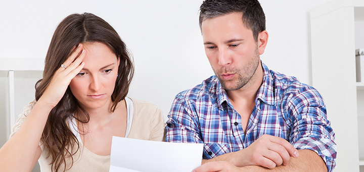 A woman and a man looking at bills