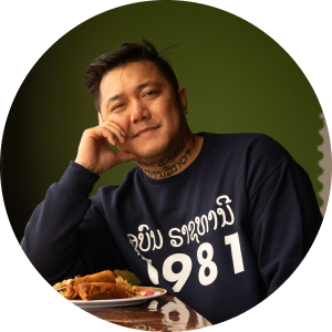 A man in a restaurant smiles over a plate of food